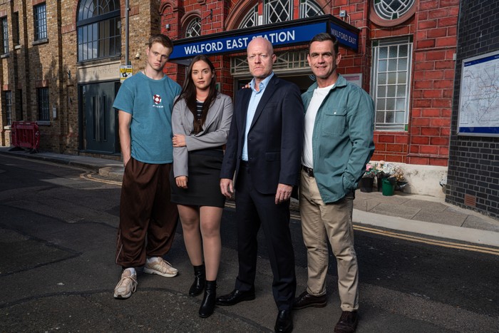 Pierre Moullier as Oscar Branning, Jacqueline Jossa as Lauren Branning, Jake Wood as Max Branning, and Scott Maslen as Jack Branning pose and stand on the exterior set to Walford tube station for EastEnders.