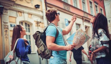 A group of people with bags and backpacks holding a map while looking at a building.