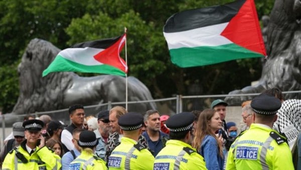 Demonstrators pass a line of police during a protest by the Palestine Action Group in London.