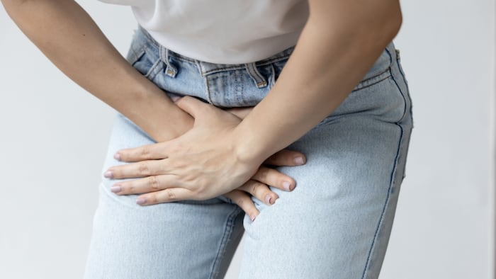 close up of person grasping pelvic area in pain