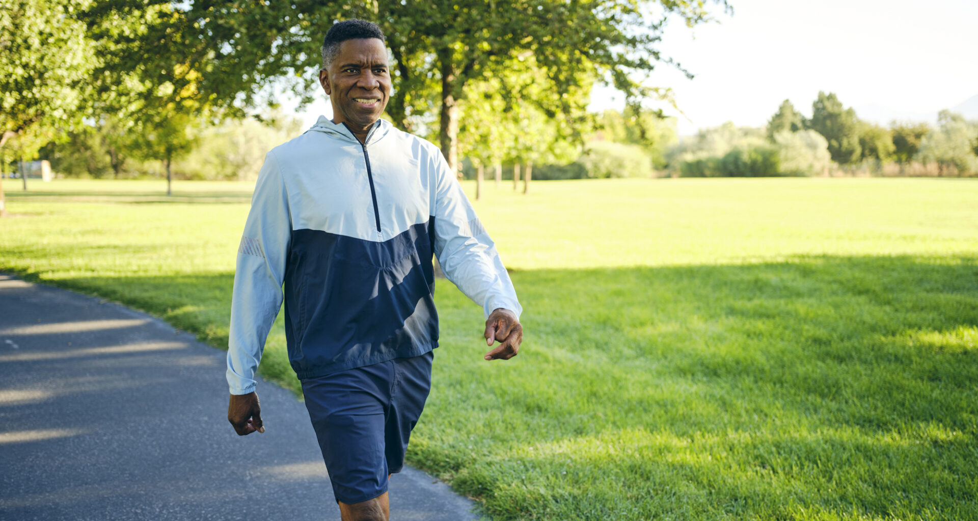 Man in activewear walking in sunny park