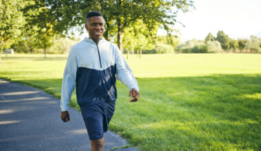 Man in activewear walking in sunny park