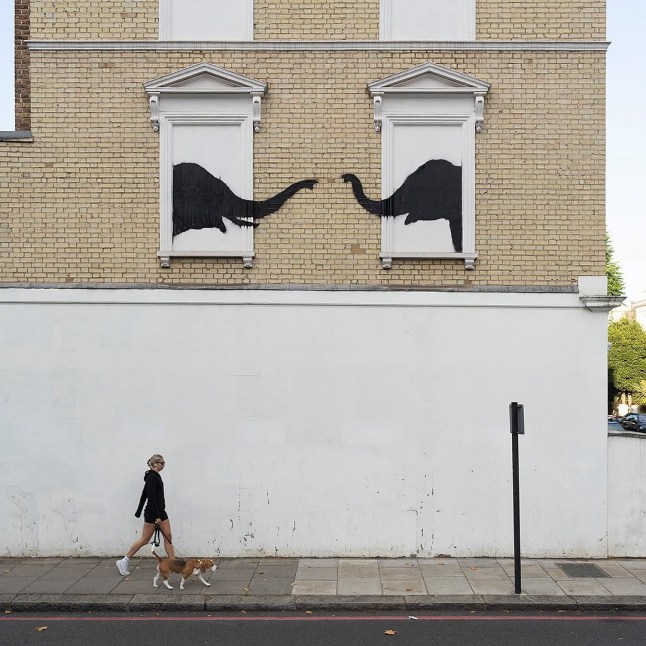 Banksy has unveiled another new artwork in London depicting two elephants poking their heads out of blocked out windows. The Bristol-based street artist shared a photo of the wall art which features two dark elephant silhouettes with their trunks stretched out towards each other on Instagram on Tuesday. It comes after Banksy revealed an artwork of a goat perched on top of a wall near Kew Bridge in Richmond on Monday.  https://www.instagram.com/p/C-U-LLVubOO/?hl=en