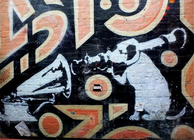 Banksy's "His Master's Voice" mural, featuring a dog with a bazooka aimed at a gramophone, is located in the courtyard of the former Cargo nightclub on Rivington Street in Shoreditch, London.