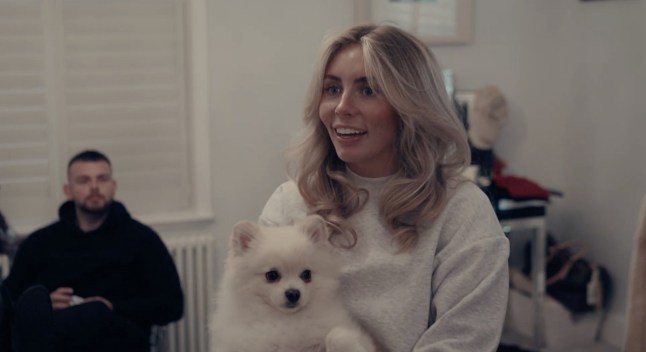 Bonnie Blue smiles at camera as she holds a dog