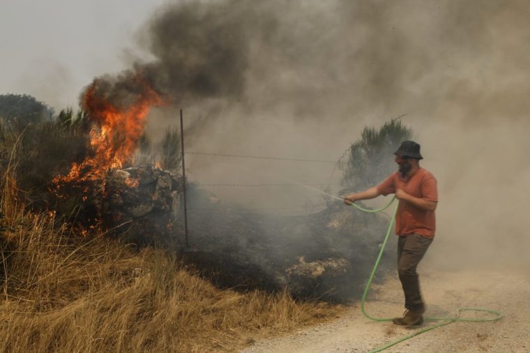Residents try to extinguish the forest fire in Pareisas, northwestern Spain, Wednesday, Aug. 13, 2025. (AP Photo/Lalo R. Villar)