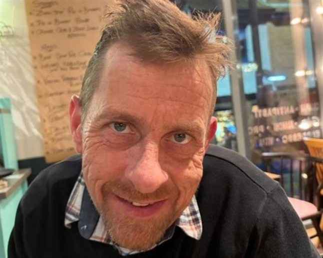 **NOT FOR USE FOR KENT LIVE** WORDS BYLINE: Millie Bowles A heartbroken wife has told of the horror of discovering her husband???s body behind their garden shed almost two days after he was killed in a freak chainsaw accident. Amy Parry had reported her husband Ed missing after returning home to their house in Seasalter, near Whitstable, and finding no trace of him. Despite police searches and enquiries, it was not until 48 hours later that Mrs Parry ??? guided by the family dog ??? found the dad-of-two???s body herself. ???To find him behind the shed was a complete and utter shock,??? she told KentOnline. ???I never thought for one second he was on the property. ???I only found him because one of my dogs kept going behind the back there, and then it just dawned on me. ???I think I???m still in shock. I feel like I???m talking about someone in a film.??? An inquest heard Mr Parry, a 54-year-old plumber and musician, suffered a catastrophic wound to his left wrist while carrying out gardening work with a handheld chainsaw. Mrs Parry, 44, told how her nightmare began when she returned home at about 4.30pm on April 21 after taking her eldest son Frederick, 18, to Ashford. She found her younger son Ralph, 13, alone at home, but no sign of her husband. She recalled: ???It was just a normal day - a bank holiday Monday. ???I came home, his wallet and everything were here. ???No cars were gone. The dogs weren???t gone. He wasn???t answering his phone. ???It was literally like he???d been abducted. ???It was bizarre from the start. It didn???t add up at all.??? Mrs Parry reported her husband missing at 8.19pm and police arrived four hours later, assessing him as a medium-risk missing person. Over the following two days, officers carried out three searches of the house, analysed CCTV and checked his financial records ??? discovering only that he had visited a Best One shop in Faversham to buy dog food and tobacco. Mrs Parry, who had been married to her husband for 17 years, explained that he had been doing some work in the neighbour???s garden that day. The neighbour confirmed this, but despite further police enquiries, his whereabouts remained unknown. It was not until 5pm on April 23 that Mrs Parry, already on the phone to 999, ran outside to officers carrying out door-to-door enquiries, saying she had found her husband???s body wedged between the shed and fence panels. Coroner Sarah Clarke confirmed there was ???evidence of gardening jobs being completed??? and in the same area was a handheld chainsaw, which ???could be seen to have blood-staining???. A police investigation confirmed there were no suspicious circumstances or third-party involvement, and toxicology tests found no substances of concern in Mr Parry???s system. After reviewing the evidence at the hearing on Wednesday, Coroner Clarke was confident Mr Parry did not intend to take his own life. At the inquest in Maidstone on Wednesday, coroner Sarah Clarke confirmed there were no suspicious circumstances and ruled the death accidental. She said no notes of intent were found, he had no previous incidents of self-harm or suicide attempts, he had a successful business, and his finances were in order. Mrs Parry said: ???They were probably the worst two days of my life because he didn???t have mental health problems, but you then analyse everything. ???I thought maybe he was really depressed and I didn???t realise.??? She said the dad-of-two ???lived for music??? and was the lead guitarist in local band The Laziathons, which has since said it cannot continue without him. She added he was ???really, really talented??? and ???extremely likeable???. ???We met when I was working at a lettings agency in Canterbury,??? she told KentOnline. ???It was my first day, and he was doing a gas certificate on one of the properties. ???He said, if you make me a cup of tea, I can give you a lift home. He was quite forward like that. ???We had common ground with our sort of music. He used to play the piano and guitar. ???His love of life was family and his music. ???We???re gutted, but Ed would want us to carry on. ???He was just a really good guy. He was really liked. I never came across anyone who didn???t like Ed. ???He was extremely likeable, extremely friendly. He was kind.??? Recording a conclusion of accidental death, the coroner said: ???I hope that the record and recording of the inquest will help with explaining things to Ed???s children in the future.??? Police review investigation Mrs Parry raised concerns about the police investigation and the failure of officers to find her husband sooner, leaving her to eventually discover his body herself. ???It should have been taken more seriously from the get-go,??? she explained. ???I made it very, very clear from the outset that this wasn't like Ed at all. ???We got an apology, but it wasn't that great, really. ???They searched next door. If they'd just looked over the fence, they would have seen him. ???There were a lot of things that were missed. But they've told me that they've put better measures in place.??? Kent Police conducted a review into its efforts to find Mr Parry following concerns raised by the family. Chief Superintendent Rob Marsh said: ???Edward Parry was reported missing from Whitstable on Monday, April 21, 2025 and enquiries to find him were carried out, including physical searches of the area, as well as CCTV and financial checks. His body was sadly found on April 23. ???Following concerns raised by his family, a comprehensive review into the search for Mr Parry was undertaken. The findings established officers were professional, helpful, and provided regular updates to the family throughout, however it was found the extent of the initial search at this property could have been broader and further learning has been identified. ???As a result, changes have been made to missing person searches including additional supervision. ???The findings of the review have been shared with Mr Parry???s family. The force has also apologised and its thoughts remain with them following their loss.??? Featuring: Ed Parry, from Seasalter, near Whitstable, was found dead almost two days after being reported missing When: 18 Aug 2025 Credit: Cover Images **All usages and enquiries, please contact info@cover-images.com - +44 (0)20 3397 3000**