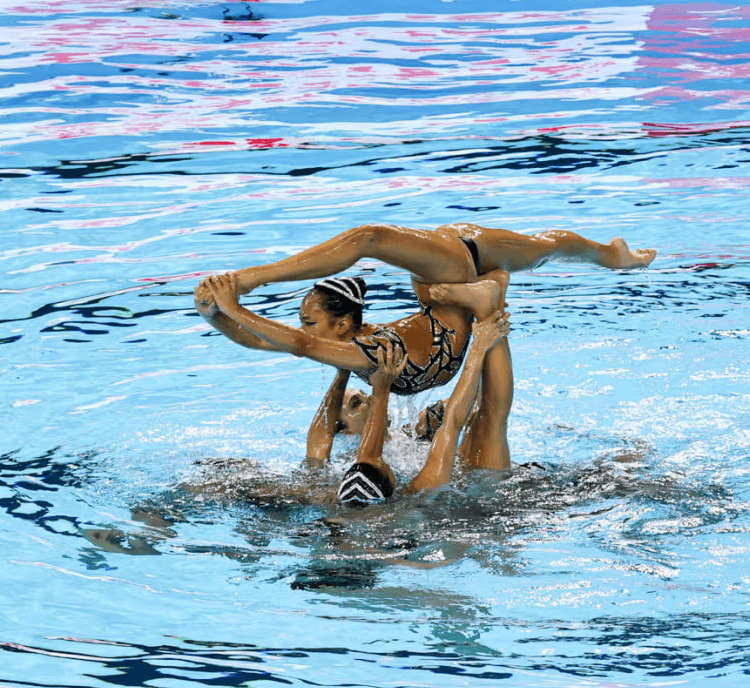 Team USA artistic swimmers perform a high-flying lift during their acrobatic routine at the 2025 World Aquatics Championships in Singapore.