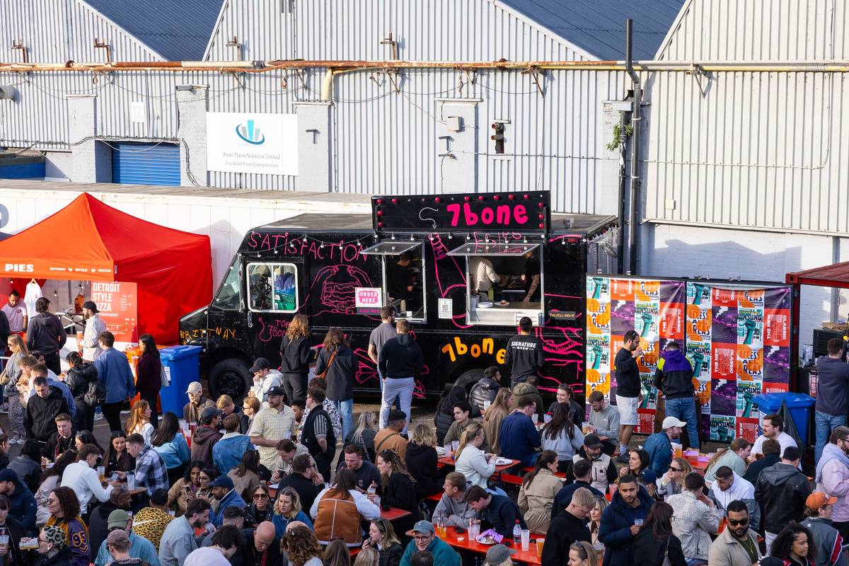 crowds of people sat outside at signature brew enjoying the sun, pints of beer, and street food from nearby vendors