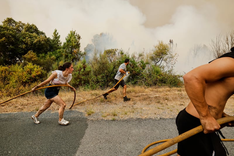 Local residents and volunteers attempt to douse an encroaching fire in Larouco, northwestern Spain. Photograph: Lalo R Villar/AP