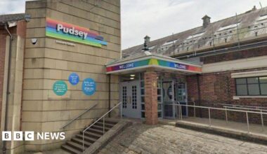 The outside of Pudsey Leisure Centre, as denoted by signage over the entrance. The front door is at the top of a set of steps.