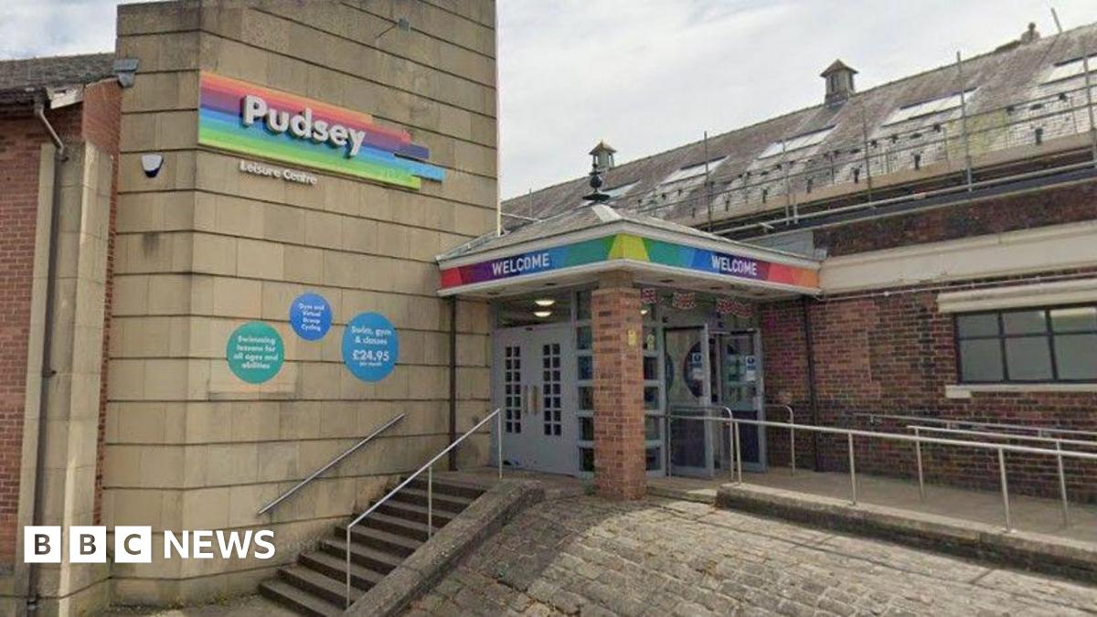 The outside of Pudsey Leisure Centre, as denoted by signage over the entrance. The front door is at the top of a set of steps.