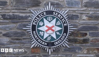 The Police Service of Northern Ireland badge on  a grey stone wall.