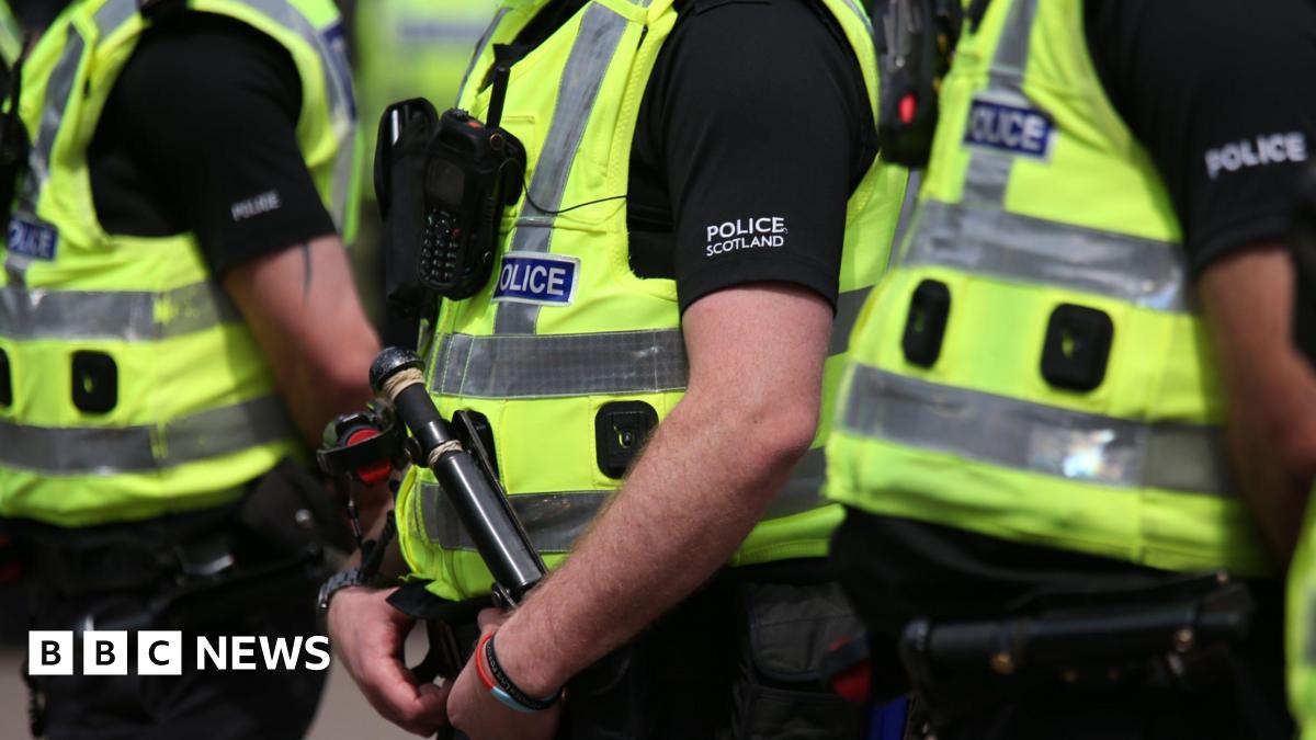 Three Police Scotland officers wearing hi-vis vests over black clothing with "Police Scotland" in white writing on the upper arm.