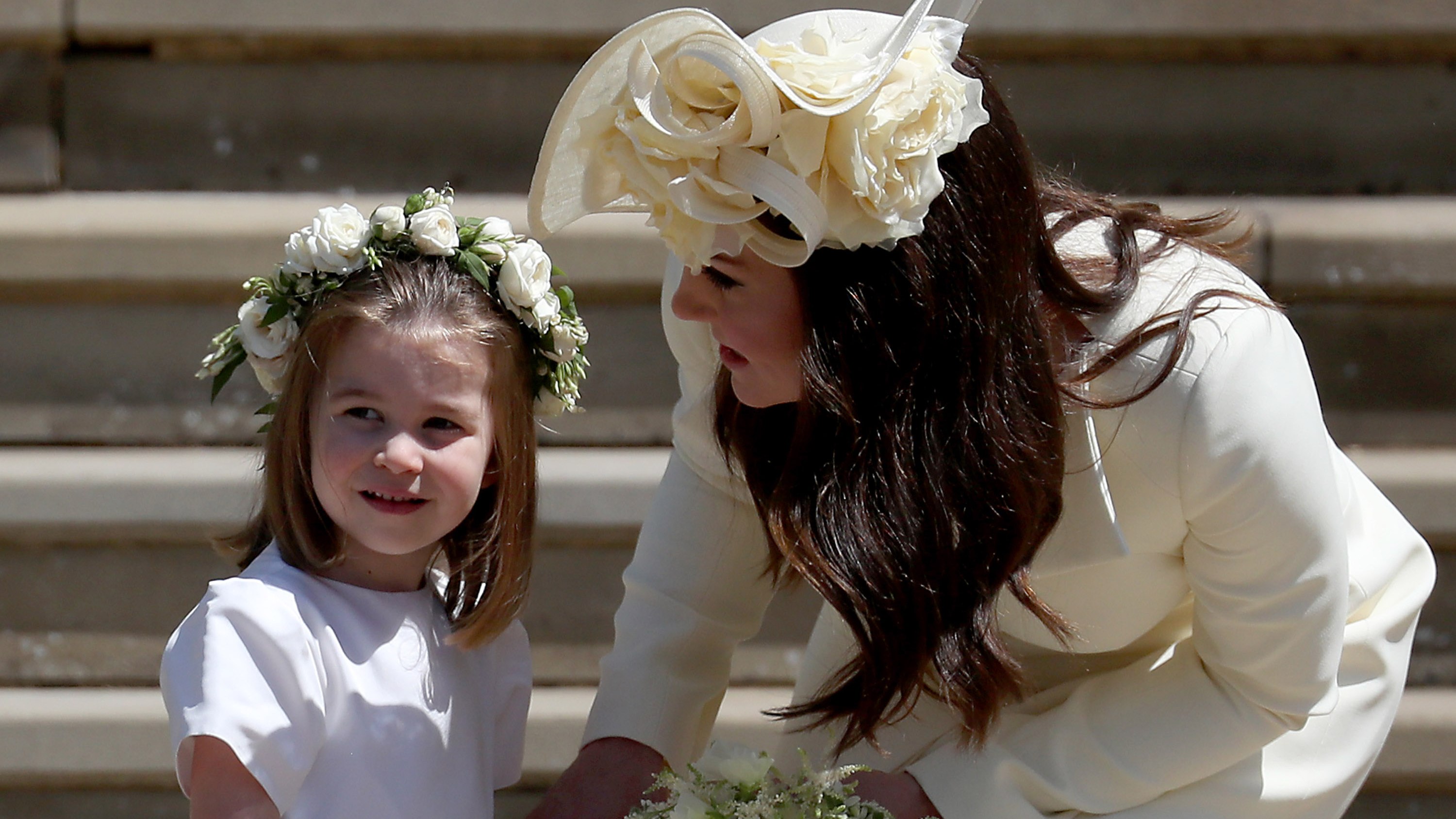 Princess Charlotte stands on the steps with her mother Catherine, Princess of Wales after the wedding of Prince Harry and Meghan Markle at St George's Chapel at Windsor Castle on May 19, 2018