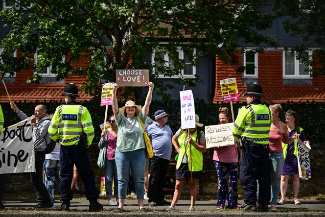 Demonstrators hold placards reading 