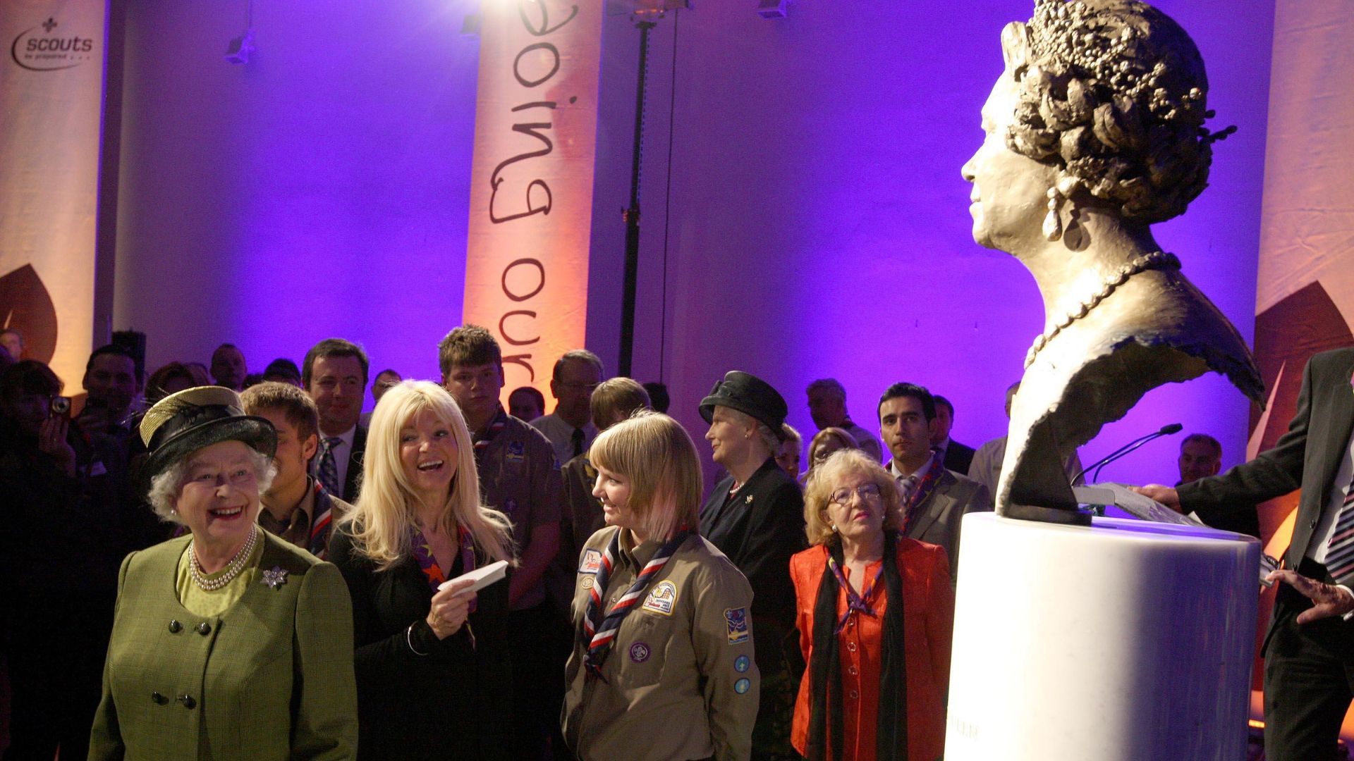 Queen Elizabeth II looks at a bronze statue of herself created by sculptor Frances Segelman in 2008