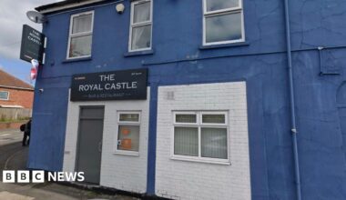 The exterior of a pub, painted blue. A sign says The Royal Castle bar and restaurant