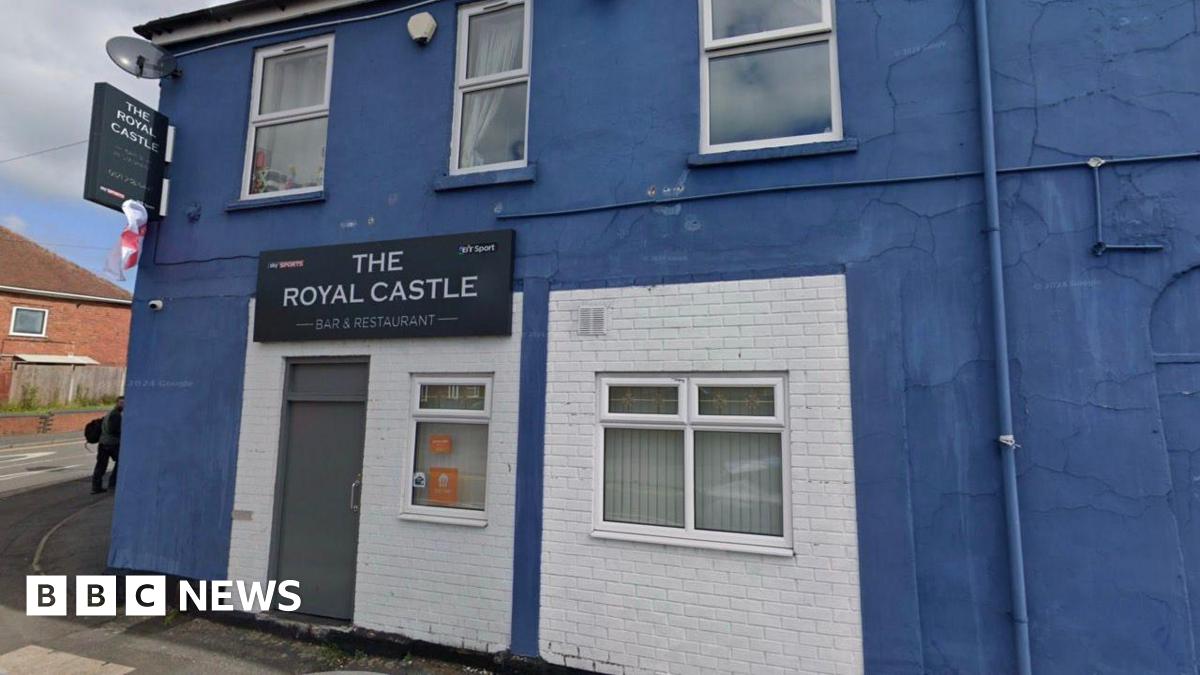 The exterior of a pub, painted blue. A sign says The Royal Castle bar and restaurant