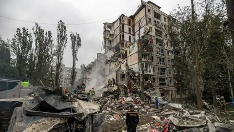 Getty Images Rescuers work at the site of a residential building destroyed by a direct hit from a Russian cruise missile during missile and drone strikes amid Russia's ongoing attack on Ukraine, in Kyiv, Ukraine, on July 31, 2025
