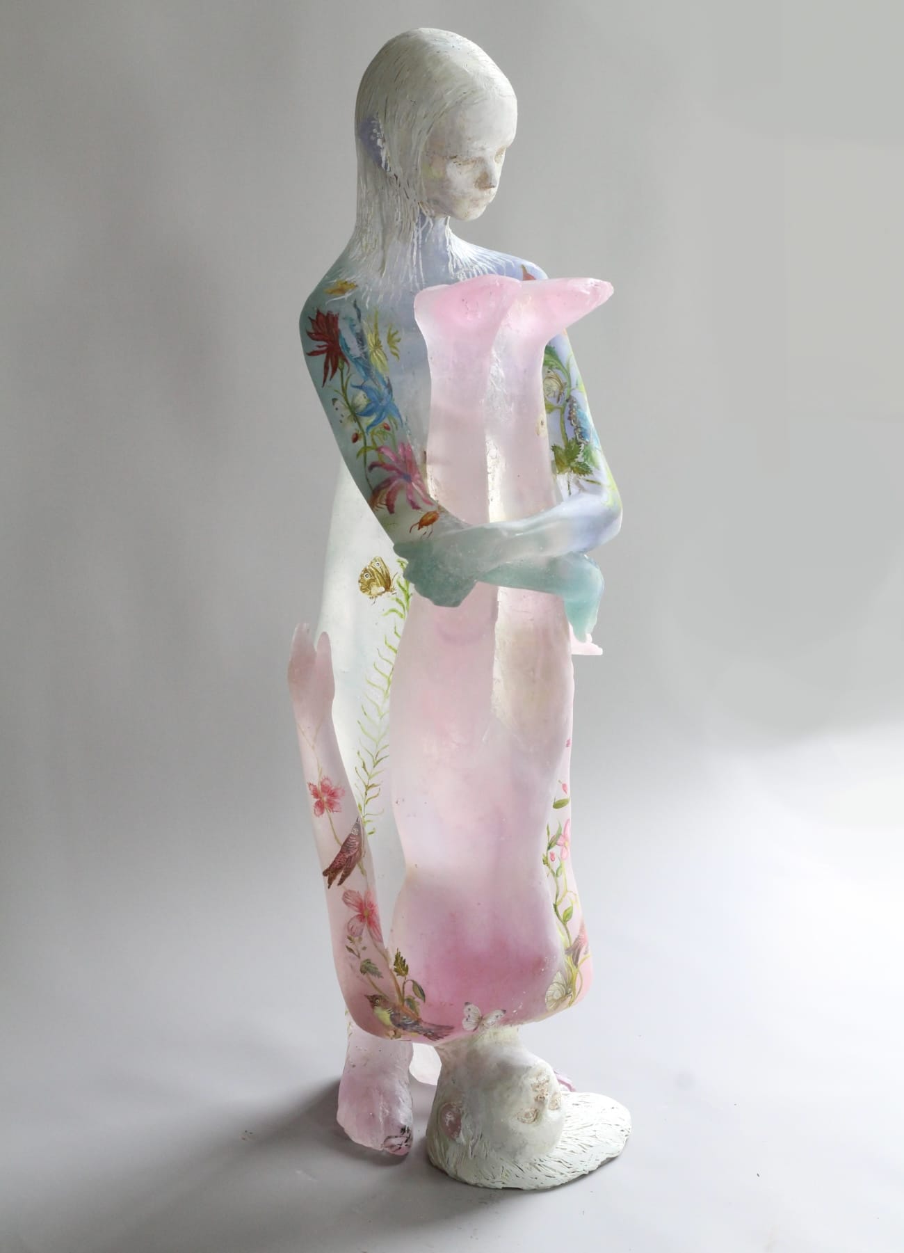 a glass sculpture of two young girls, one holding the other upside down