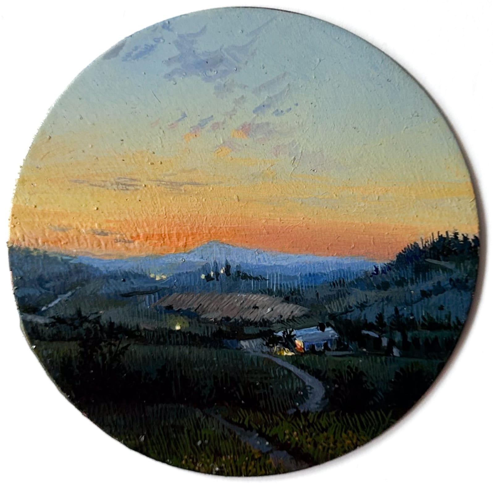 a tiny round painting of the Italian countryside at sunrise