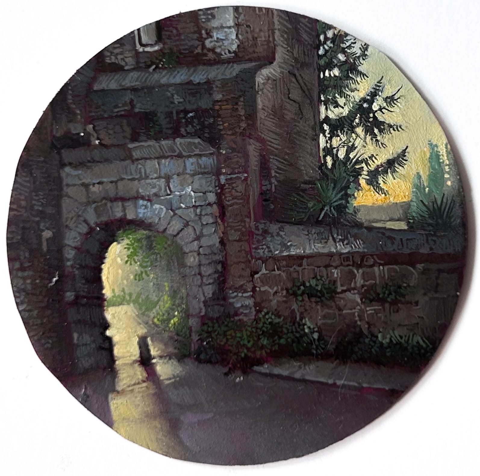 a tiny round painting of a stone archway
