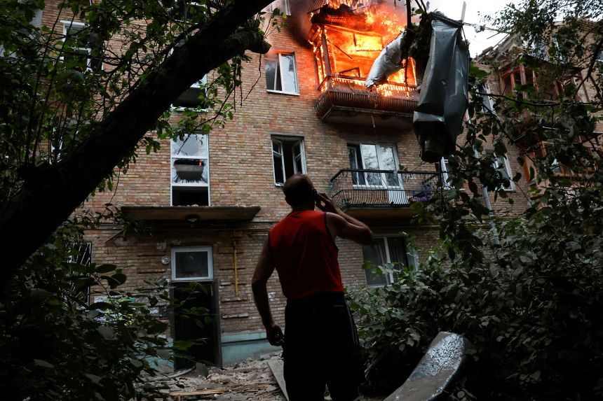 A resident looks on at the site of an apartment building hit during Russian missile and drone strikes in Kyiv, Ukraine, on July 31.