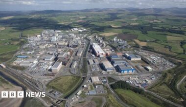 An aerial view of the Sellafield site. It is a large industrial-looking estate with several buildings and roads, surrounded by fields.
