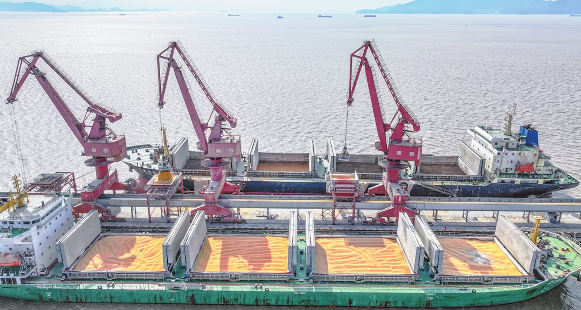 A cargo ship unloads a shipment of soybeans at the Zhoushan Port in East China
