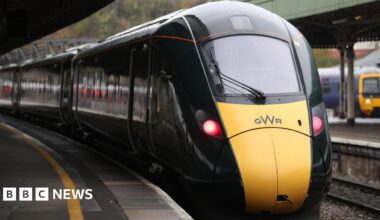 A yellow and green train with the GWR logo on the front pulls in to Bristol Temple Meads.