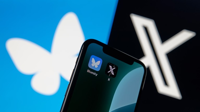 Icons of rival social networks Bluesky and X displayed on a smartphone screen against a background comprising of the two logos side-by-side.