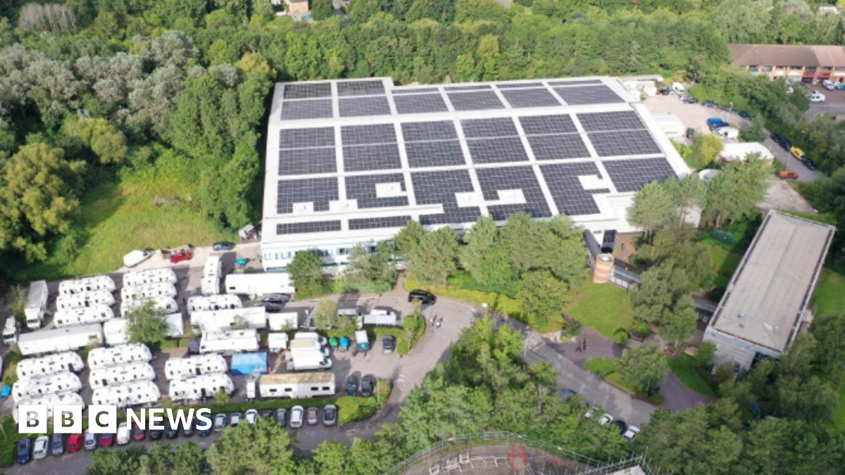 A view of The Bottle Yard Studios site from the air. It shows solar panels on the roof, trees, shrubbery and parked cars.