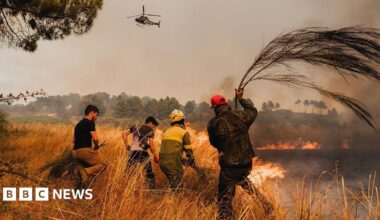 Airborne brigadiers and local residents fight a wildfire to prevent it from reaching houses in Vilela Seca, Portugal, on 19 August 2025.