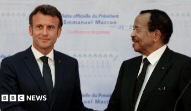 France's President Emmanuel Macron (L) and Cameroon's President Paul Biya (in matching black suits, white shirts and black ties) shake hands during a press conference in Yaounde, on July 26, 2022