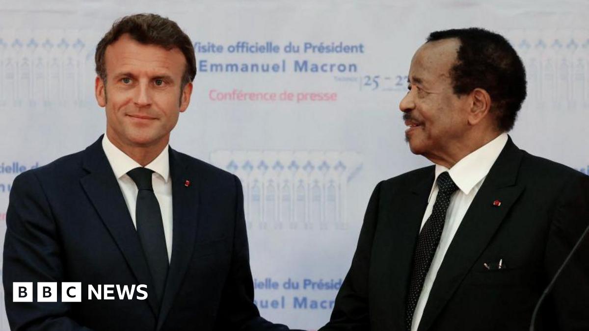 France's President Emmanuel Macron (L) and Cameroon's President Paul Biya (in matching black suits, white shirts and black ties) shake hands during a press conference in Yaounde, on July 26, 2022