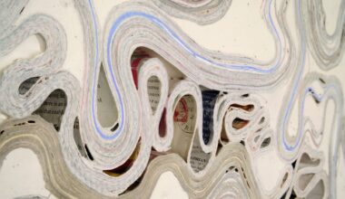a detail of an abstract wall artwork by Jessica Drenk using repurposed junk mail and plaster in curving forms