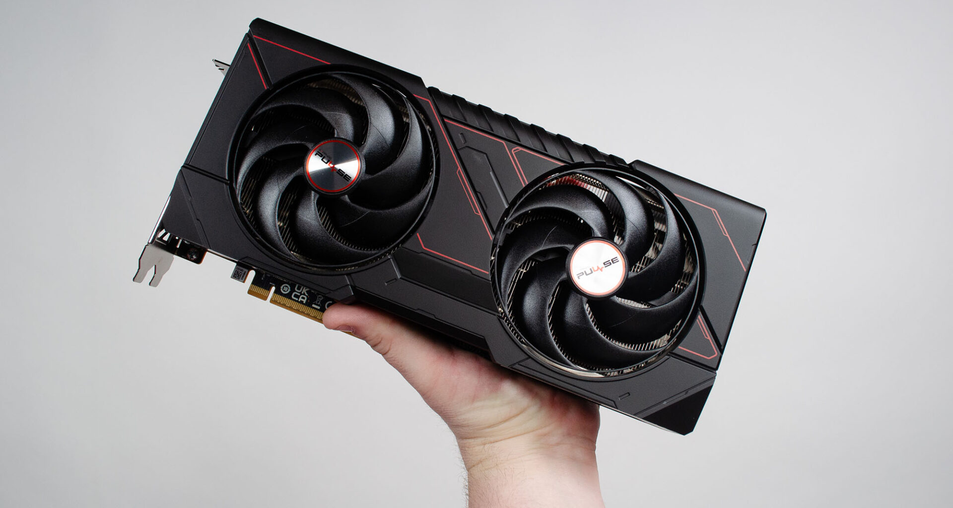 A masculine hand holding an AMD Radeon RX 9070