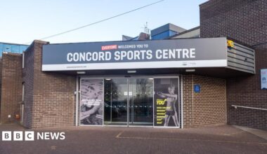 A sports centre entrance with sliding glass doors and photographs of children swimming and exercising at the gym