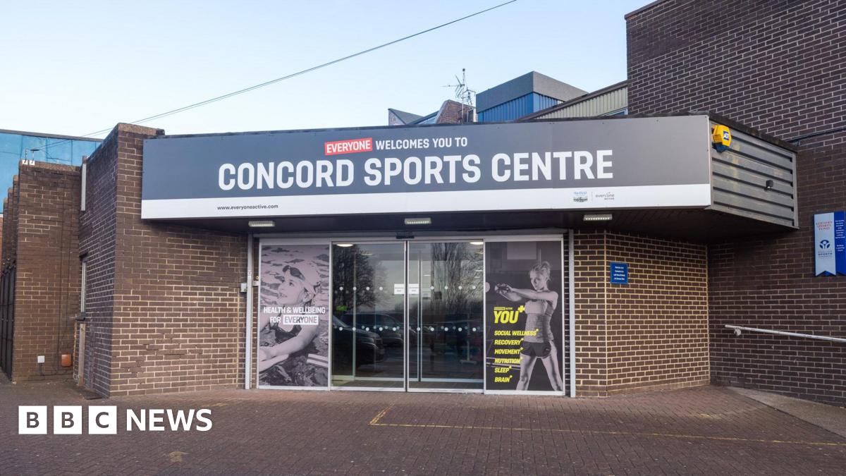 A sports centre entrance with sliding glass doors and photographs of children swimming and exercising at the gym