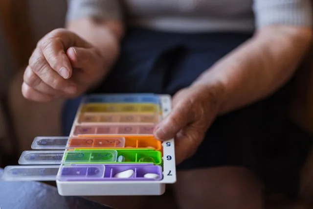 Dobrila Vignjevic/Getty Images A person placing pills in a daily pill container.