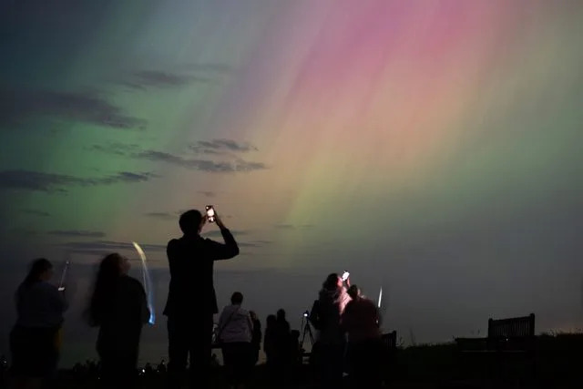 Ian Forsyth/Getty People visit St Mary's lighthouse in Whitley Bay to see the aurora borealis, commonly known as the northern lights, on May 10, 2024