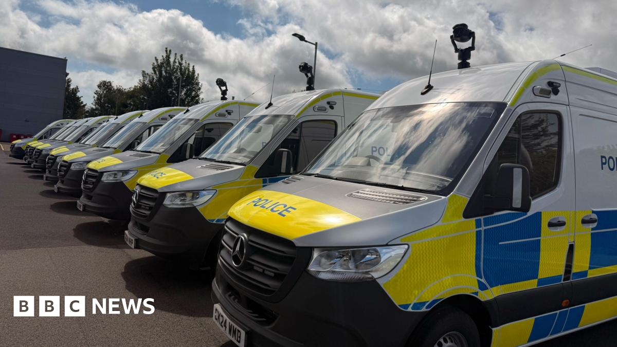 Nine police vans lined up with cameras attached to the top