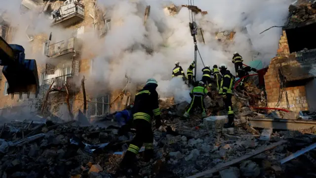 Rescuers work at the site of an apartment building which was hit by Russian missile and drone strikes,