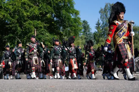 PA Media The pipe band of 3 & 4 SCOTS, Royal Regiment of Scotland as King Charles III carries out an inspection of the Balaklava Company, 5th Battalion, The Royal Regiment of Scotland, at the gates of Balmoral, as he takes up summer residence at the castle.