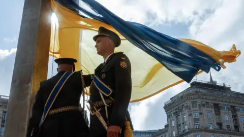 EPA The servicemen of Ukrainian Guard of Honor raise the National Flag in downtown Kyiv, Ukraine, 23 August 2025.