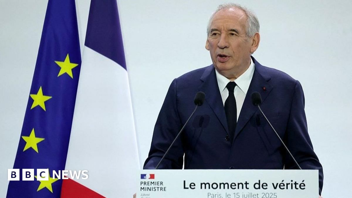 Francois Bayrou stands in front of a lectern reading "The moment of truth". Behind him are a French and an EU flag