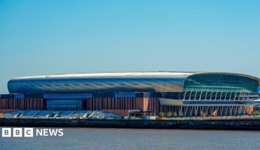 Image shows the Hill Dickinson Stadium, home to Everton FC. It is an oval-shaped stadium that sits on the Liverpool waterfront to the north of the city.