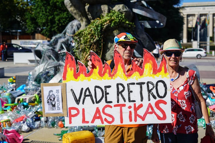 protesters with sign saying 'vade retro plastikas'