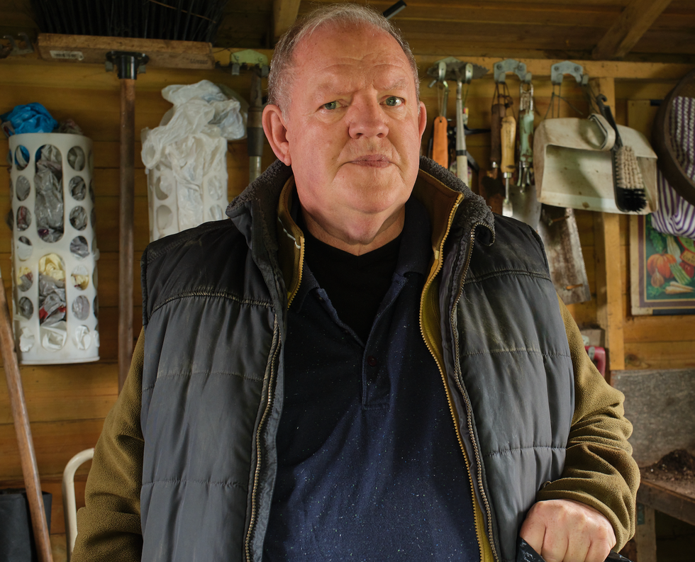 person in a shed surrounded by tools and materials